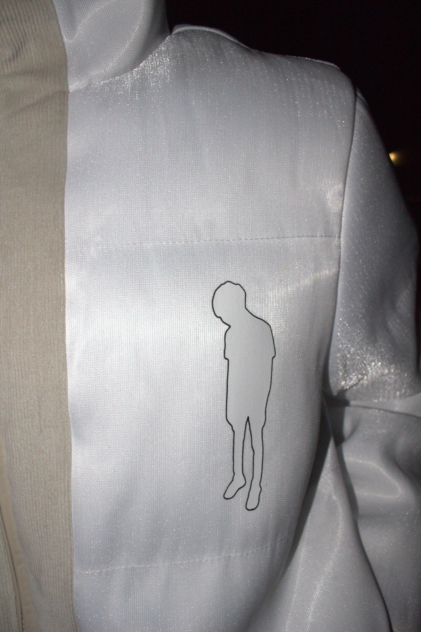 Silver seat with a black outline of a person on a beige background