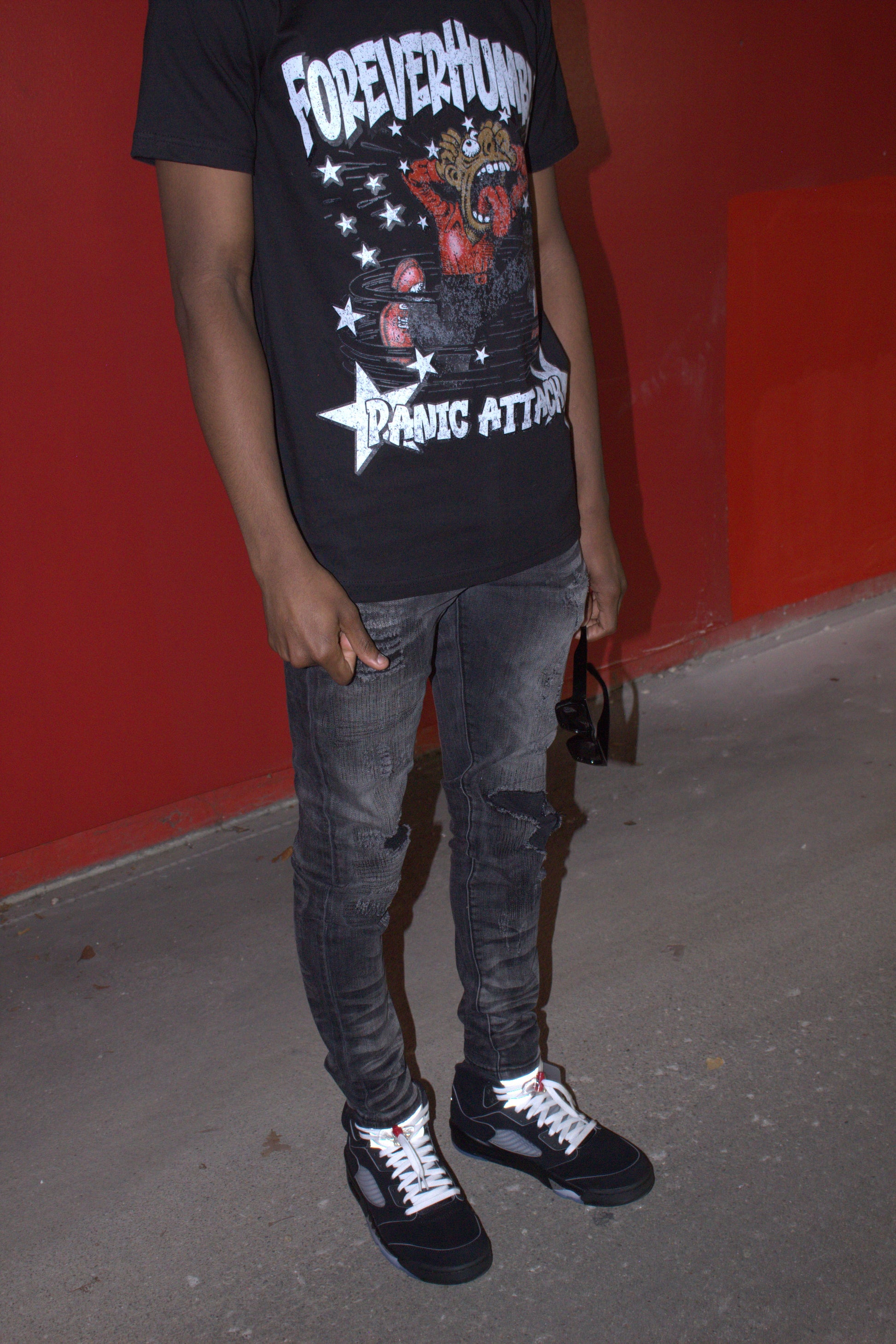 Person wearing a black graphic t-shirt with text and design