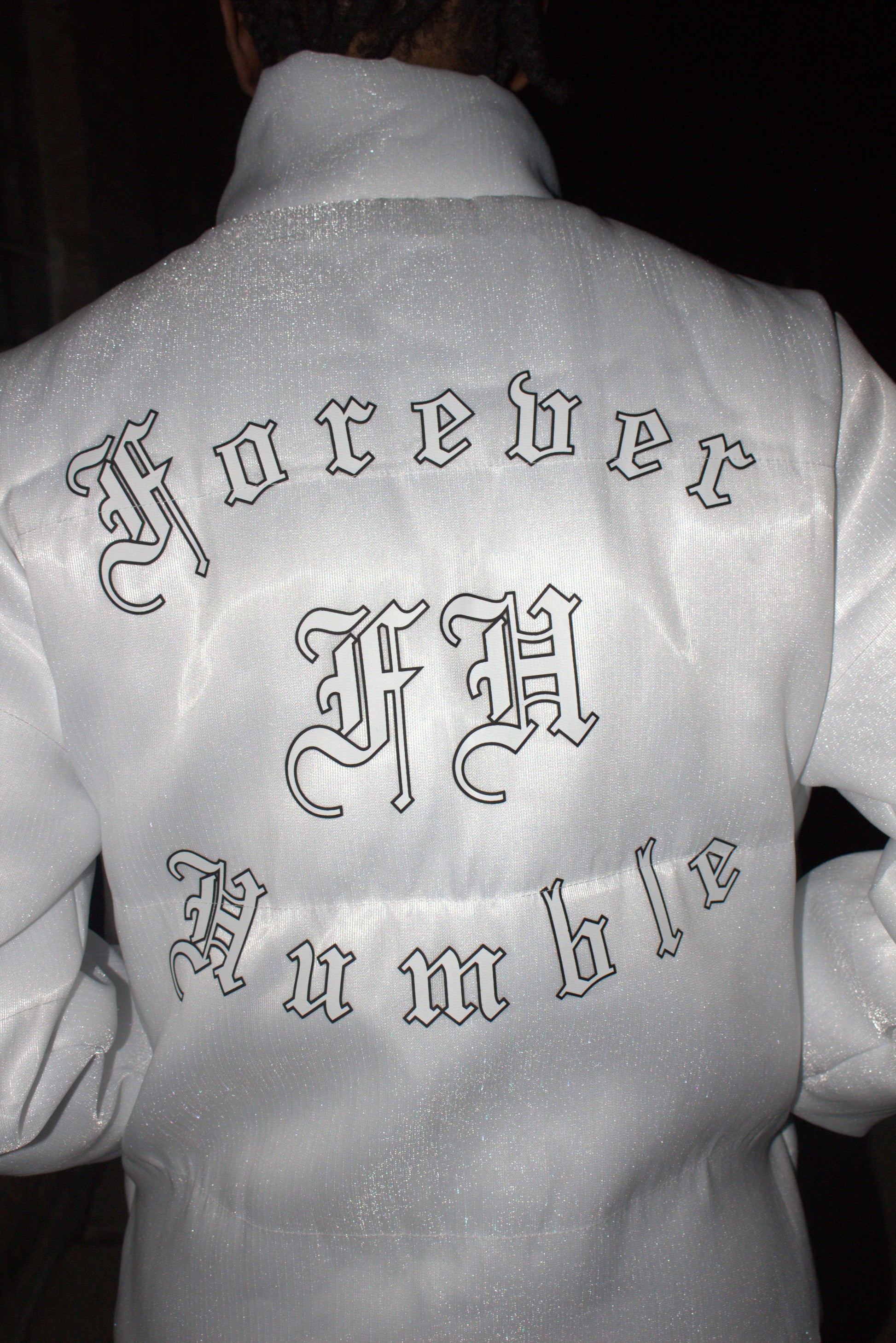Close-up of a white garment with embroidered patterns on a dark background
