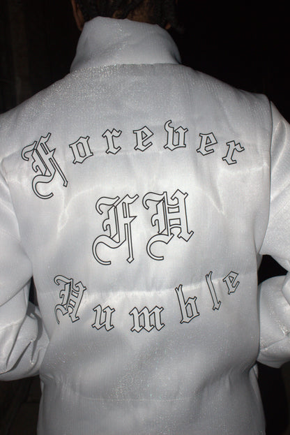 Close-up of a white garment with embroidered patterns on a dark background