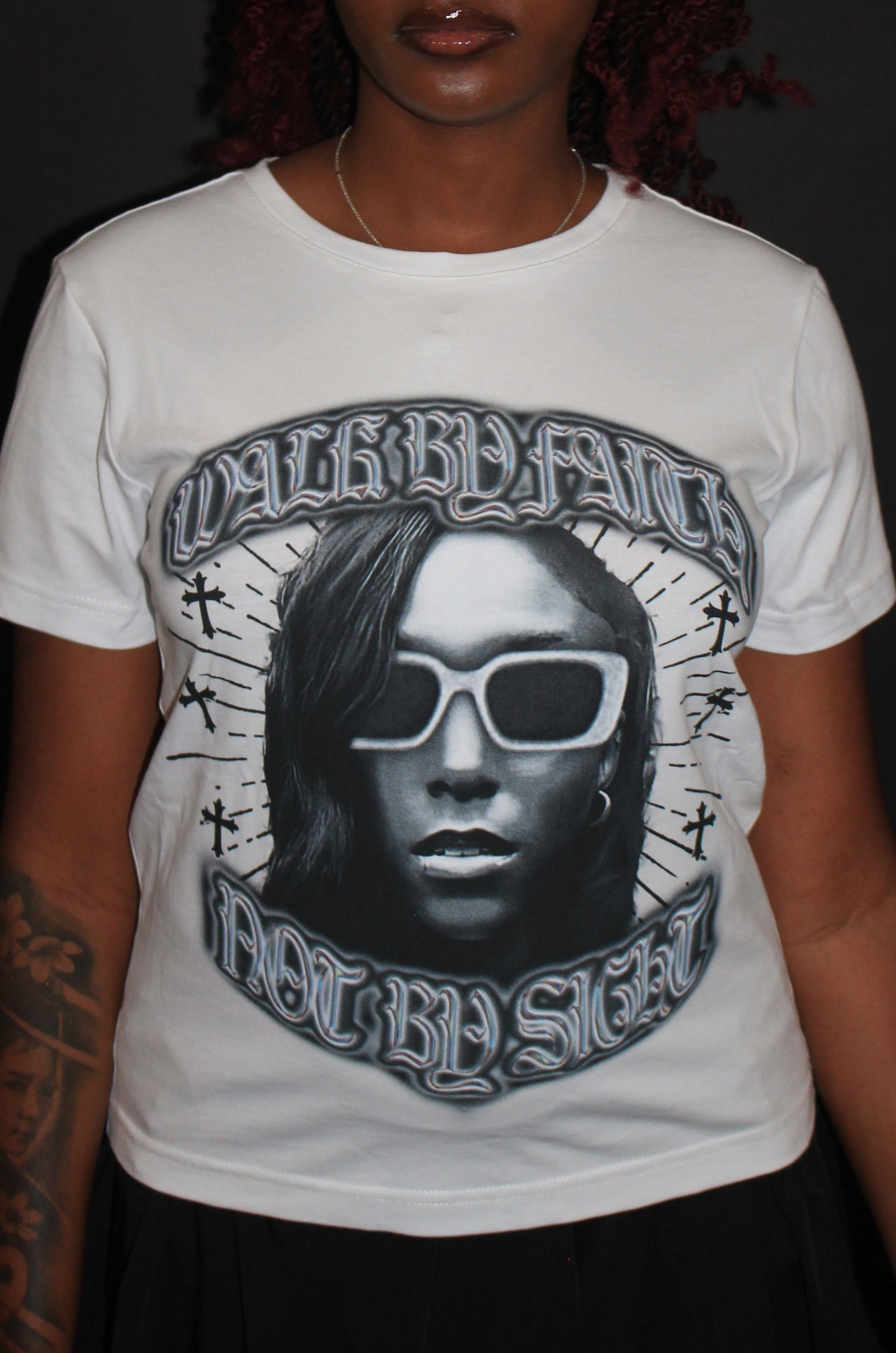 Person wearing a white t-shirt with a graphic design on a black background