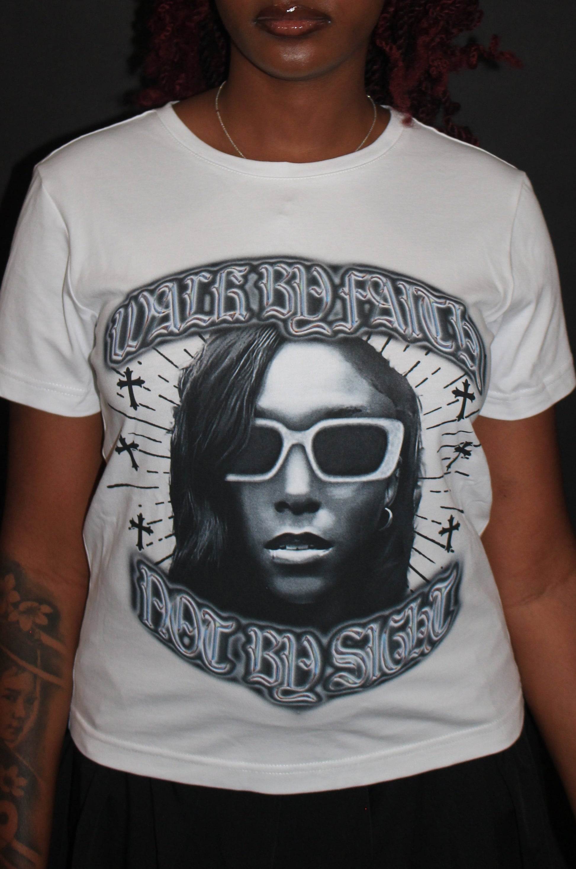 Person wearing a white t-shirt with a graphic design on a black background