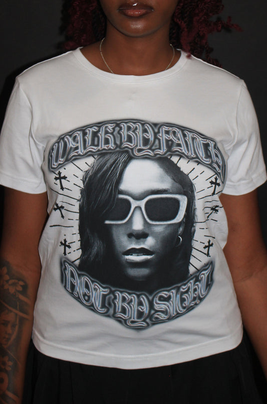 Person wearing a white t-shirt with a graphic design on a black background